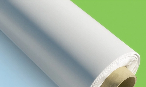 A close-up of a rolled-up sheet of white fabric or paper, with a cardboard core, placed on a surface that fades from light blue to green. | GenFlex